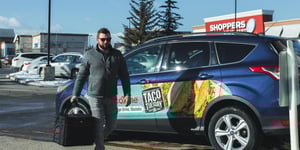 Food delivery driver walking past his branded vehicle